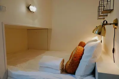 a bed with white pillows and a lamp in a room at City center Amstel river Houseboat Kom en Zie in Amsterdam