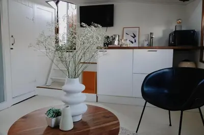 a white vase sitting on a table in a kitchen at City center Amstel river Houseboat Kom en Zie in Amsterdam