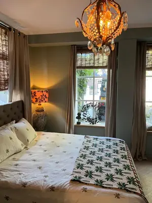 a bedroom with a large bed and a chandelier at Strandrit in Groet