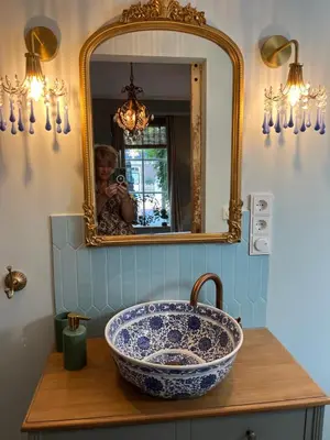 a woman taking a picture of a sink in a bathroom at Strandrit in Groet