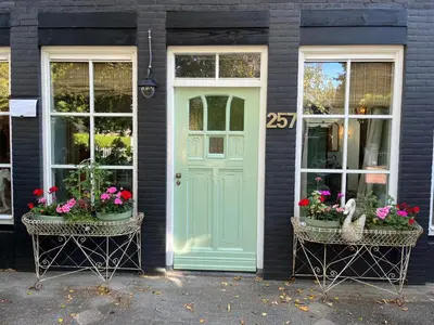 a house with a green door and two windows at Strandrit in Groet