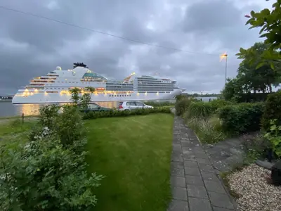 a cruise ship is docked in the water at Hemhuisje in Zaandam