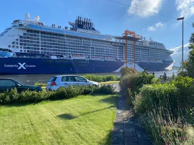 a cruise ship in the water with a car parked at Hemhuisje in Zaandam