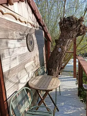a wooden table and chairs next to a tree at Sweet Treehouse in Westbeemster