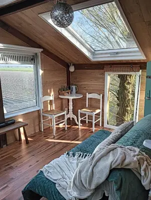 a bedroom with a bed and a window and a table at Sweet Treehouse in Westbeemster