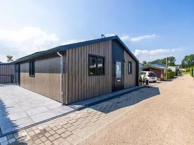 a small wooden building with a driveway at Karper Vakantiepark De Groote Vliet in Wervershoof