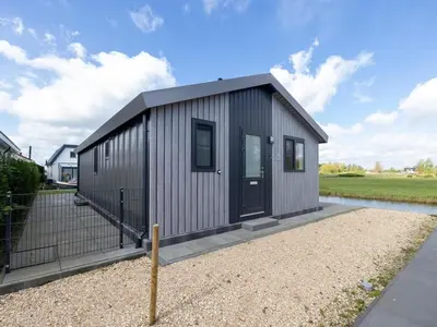 a small metal building with a black door at Karper Vakantiepark De Groote Vliet in Wervershoof