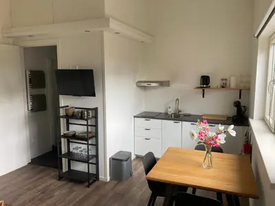a kitchen with a table with a vase of flowers on it at Boomzicht in Ter Aar