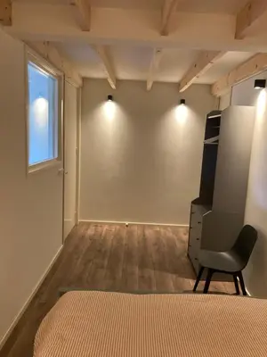 a room with a chair and a wall with lights at Boomzicht in Ter Aar