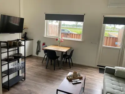 a living room with a table and a couch at Boomzicht in Ter Aar