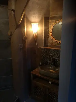 a bathroom with a sink and a light on the wall at Noorse Viking kamer en suite in Westbeemster