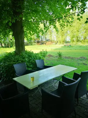 a white table and chairs with a drink on top at Noorse Viking kamer en suite in Westbeemster