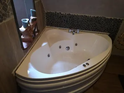 a bath tub sitting next to a toilet in a bathroom at Noorse Viking kamer en suite in Westbeemster