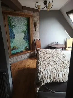 a bedroom with a bed and a painting on the wall at Noorse Viking kamer en suite in Westbeemster