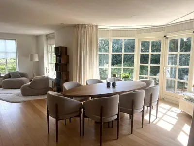 a living room with a dining room table and chairs at Villa Louise in Bergen aan Zee