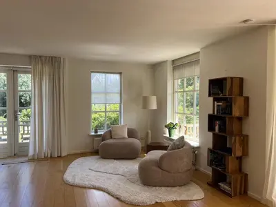 a living room with two chairs and a rug at Villa Louise in Bergen aan Zee