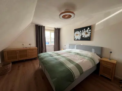 a bedroom with a bed and a window at Villa Louise in Bergen aan Zee