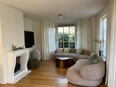 a living room with a couch and a fireplace at Villa Louise in Bergen aan Zee
