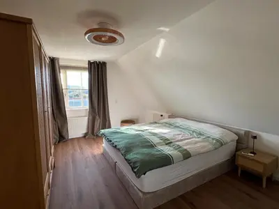 a bedroom with a bed and a window at Villa Louise in Bergen aan Zee