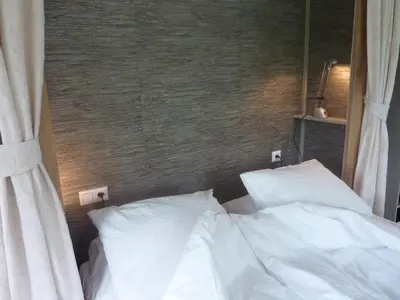 a bed with white sheets and pillows in a room at B&B BLoom in Amsterdam