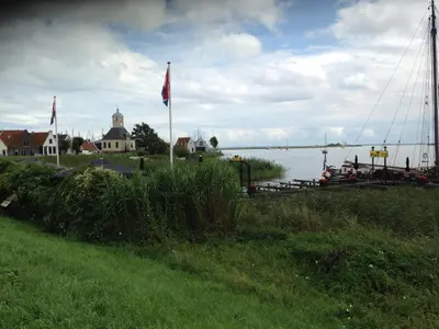 a body of water with a flag and a harbor at B&B BLoom in Amsterdam