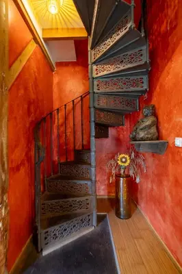 a spiral staircase in a room with red walls at Reijgershof Art Deco Room with private bathroom in Amsterdam