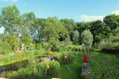 a garden with a pond and a gazebo at Reijgershof Art Deco Room with private bathroom in Amsterdam