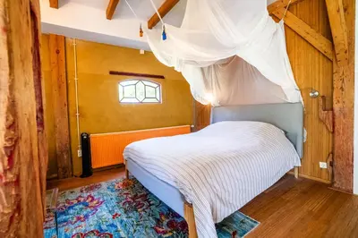 a bedroom with a canopy bed with a window at Reijgershof - The Barok lounge in Amsterdam