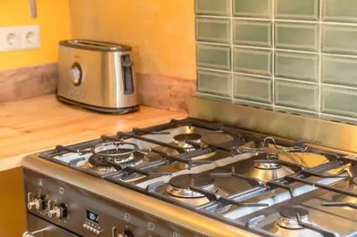 a stove top oven in a kitchen with a toaster at Reijgershof - Yurt Experience with garden view in Amsterdam