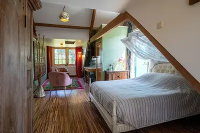 a bedroom with a canopy bed and a desk at Reijgershof - Bali Suite with private terrace in Amsterdam