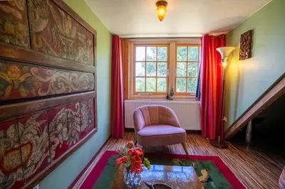 a living room with a chair and a window at Reijgershof - Bali Suite with private terrace in Amsterdam
