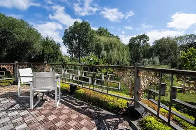 a white chair sitting on a brick patio next to a fence at Reijgershof - Bali Suite with private terrace in Amsterdam