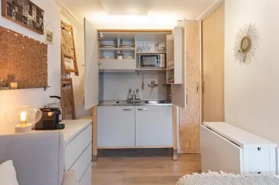 a small kitchen with a sink and a microwave at Guesthouse De Drukkerij in Zandvoort