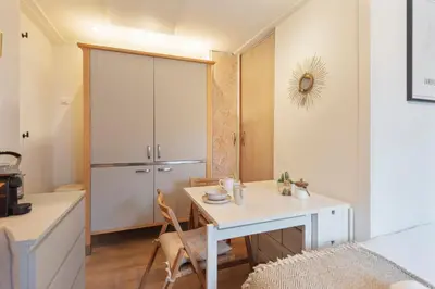 a kitchen with a white table and a desk in a room at Guesthouse De Drukkerij in Zandvoort