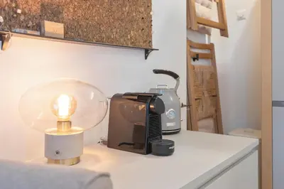 a kitchen counter with a coffee maker and a lamp at Guesthouse De Drukkerij in Zandvoort