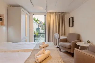 a bedroom with a bed and a couch and a chair at Guesthouse De Drukkerij in Zandvoort