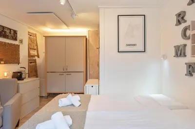 a bedroom with a bed with towels on it at Guesthouse De Drukkerij in Zandvoort