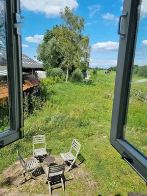 a view from a window of a field with chairs and a table at The Barn in Loosdrecht