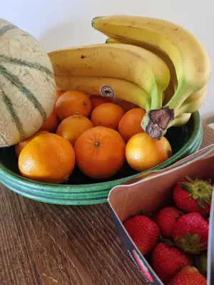 a bowl of fruit with bananas oranges oranges and strawberries at The Barn in Loosdrecht