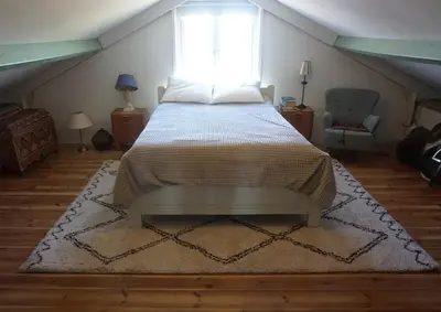 a bedroom with a bed and a window in a attic at The Barn in Loosdrecht