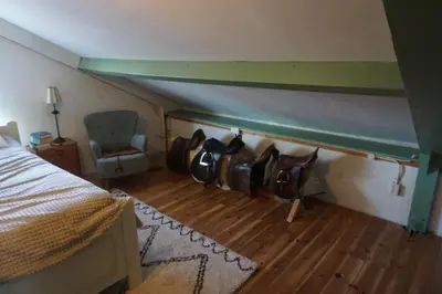 a attic room with a bed and a chair at The Barn in Loosdrecht