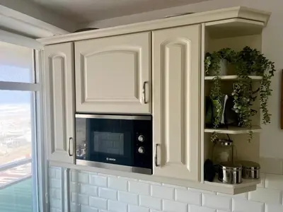 a white cabinet with a microwave in a kitchen at Nicky's Seaview in Zandvoort
