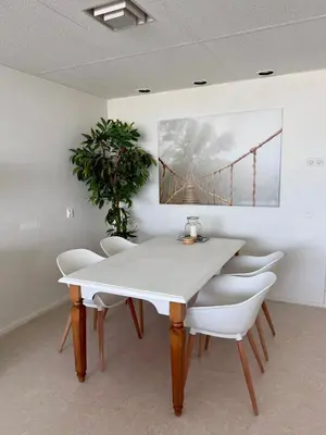 a dining room with a white table and chairs at Nicky's Seaview in Zandvoort