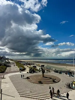 a group of people walking on a sidewalk near the beach at Nicky's Seaview in Zandvoort
