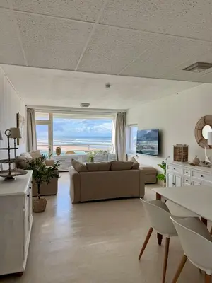 a living room with a couch and a large window at Nicky's Seaview in Zandvoort