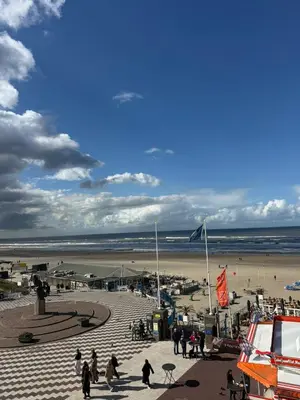 a group of people walking on the beach at Nicky's Seaview in Zandvoort
