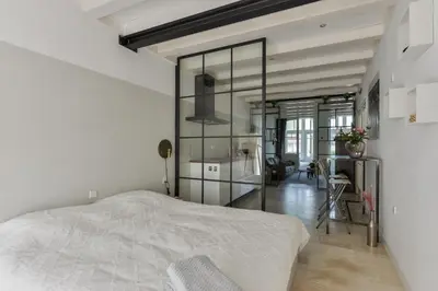 a bedroom with a bed and a large glass wall at Villa Loft Apartment with Light Garden in Zandvoort