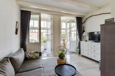 a living room with a couch and a tv at Villa Loft Apartment with Light Garden in Zandvoort