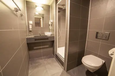 a bathroom with a toilet and a sink at Hotel Library Amsterdam in Amsterdam