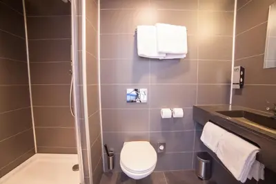 a bathroom with a toilet and a sink and a shower at Hotel Library Amsterdam in Amsterdam